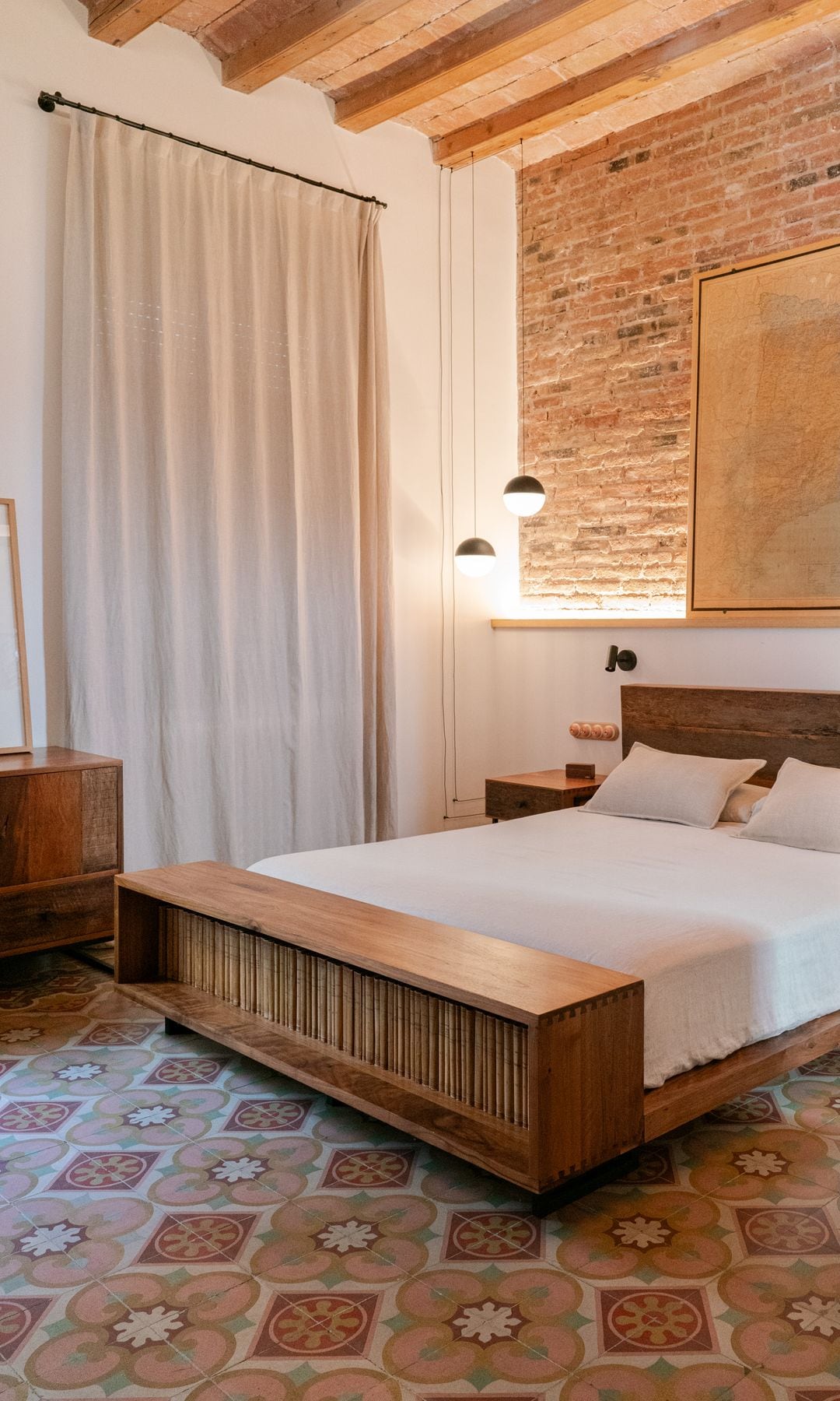Dormitorio con suelo hidráulico, bóvedas catalanas, cama de madera con librería y banco integrado, cortinas