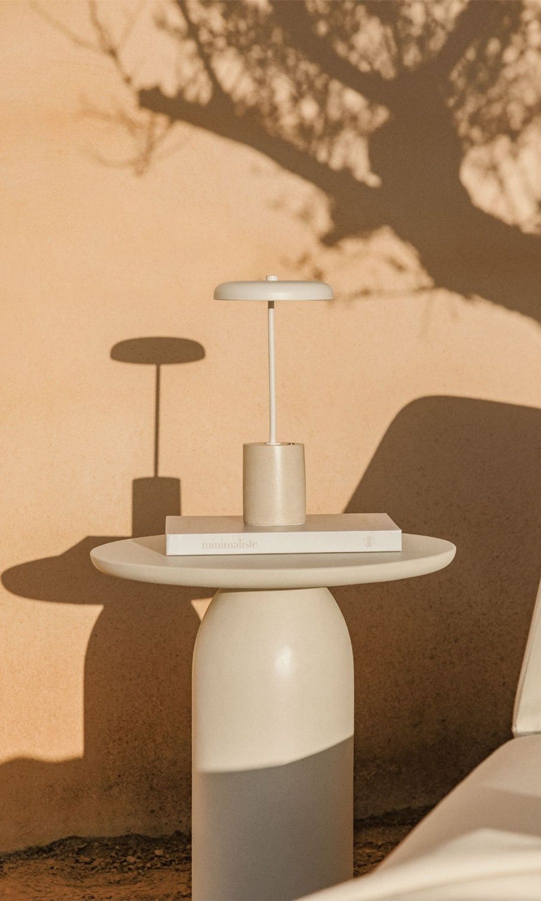 Mesa auxiliar de exterior con lámpara beige de sobremesa tipo 'seta'