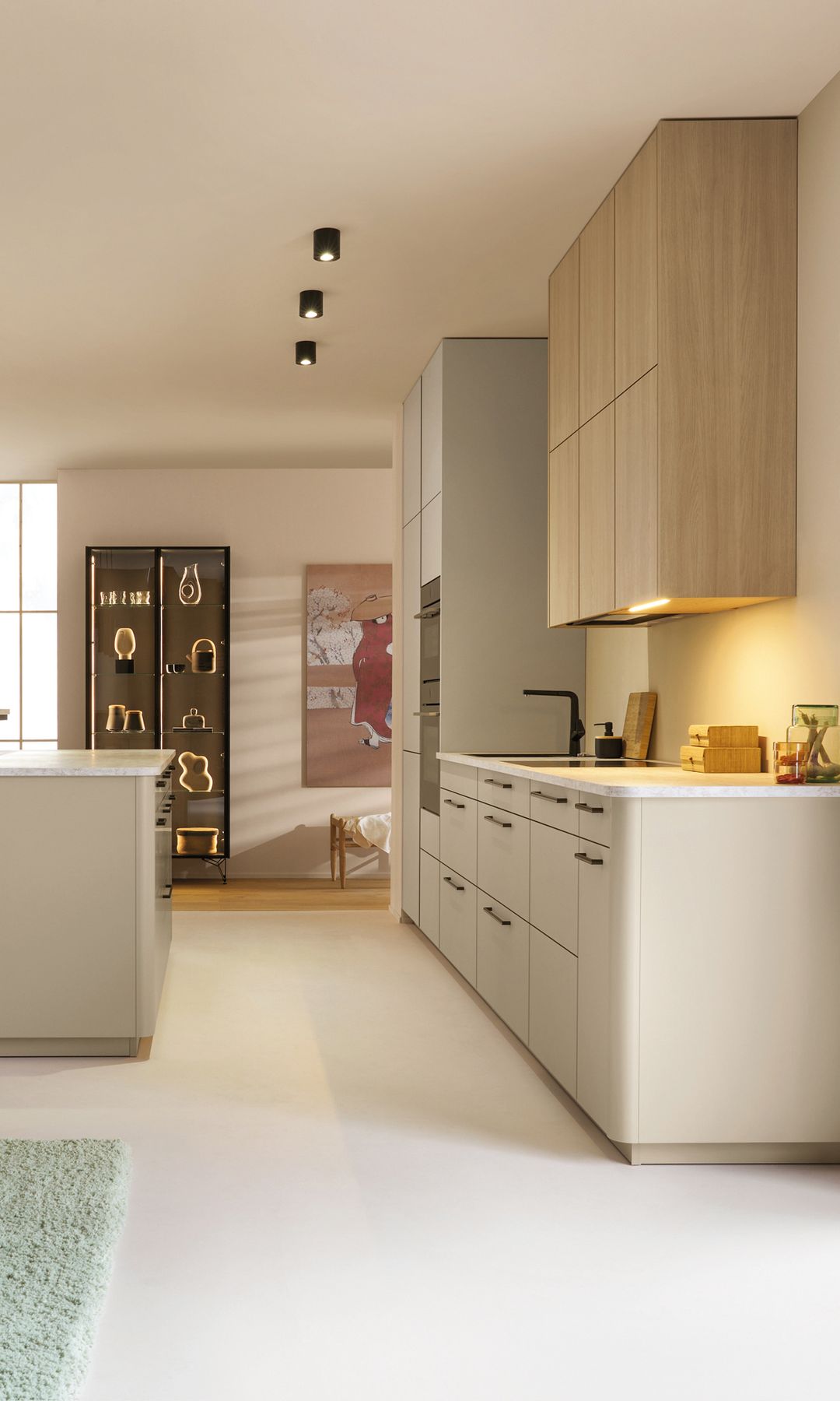 Cocina blanca y de madera, grandes ventanales, lámparas de techo, focos bajo los armarios superiores 