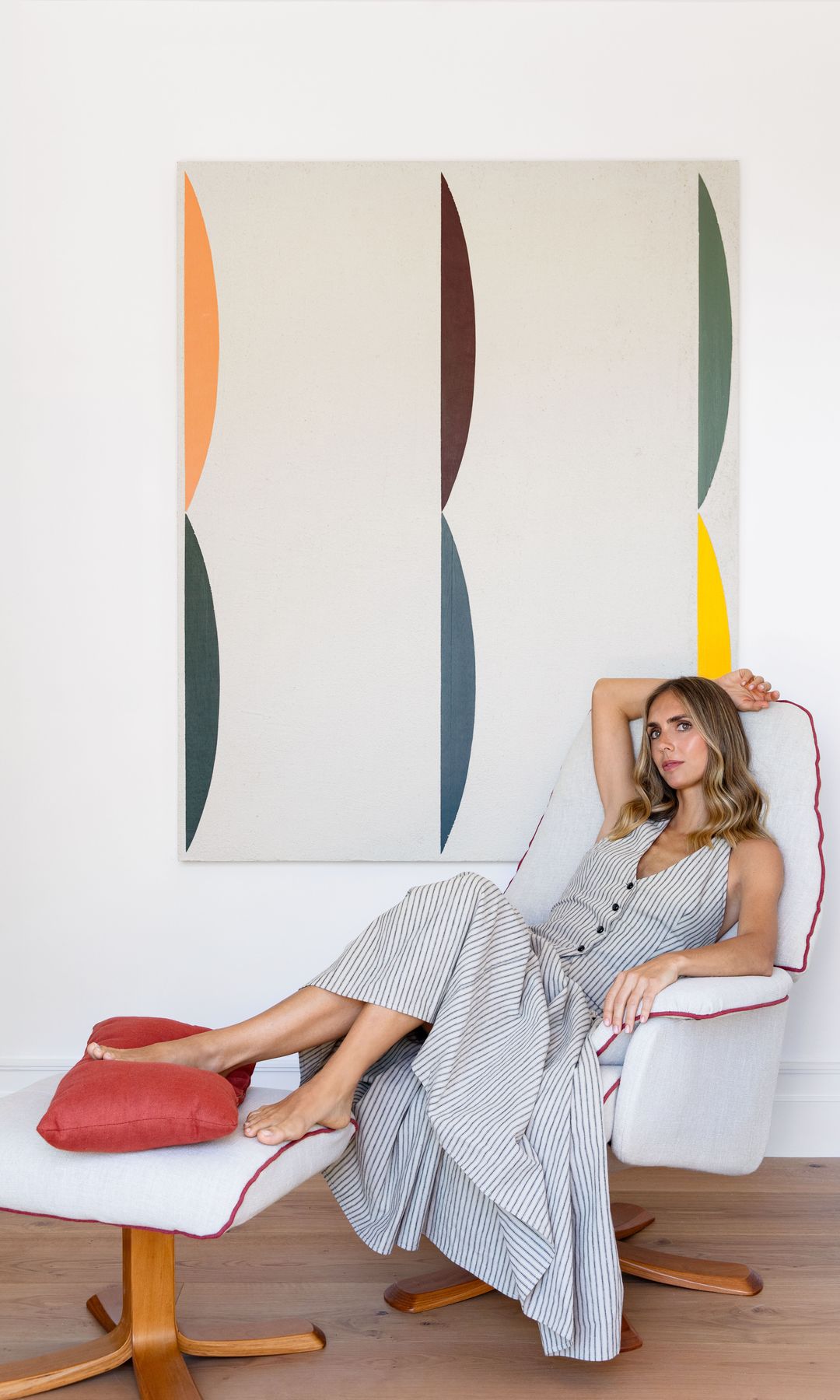 ELEGANTE Y NATURAL
Nuestra anfitriona, recostada en una butaca con reposapiés a juego, retapizada por Pilar. Como telón de fondo, un enorme cuadro de Alejandro Jaque, de Orellana Arte. 