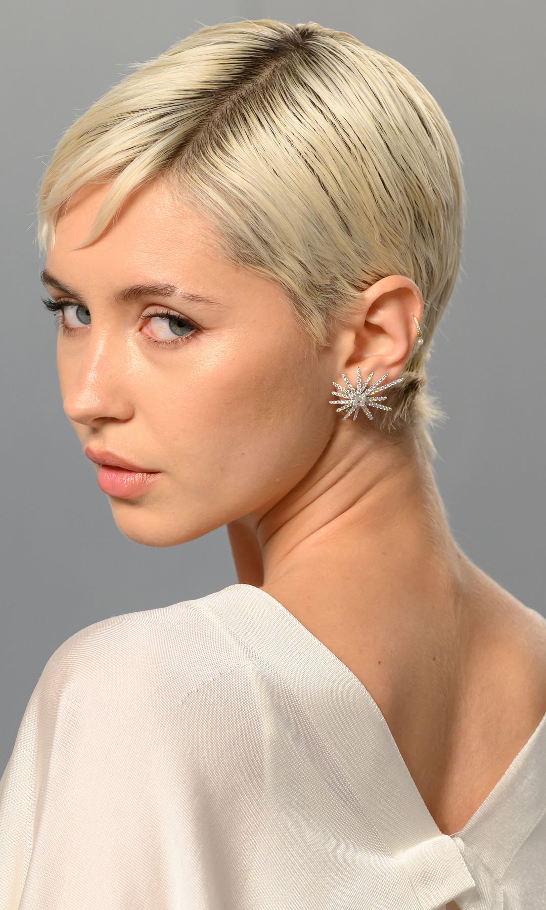 Iris Law con vestido blanco y pendientes de diamantes