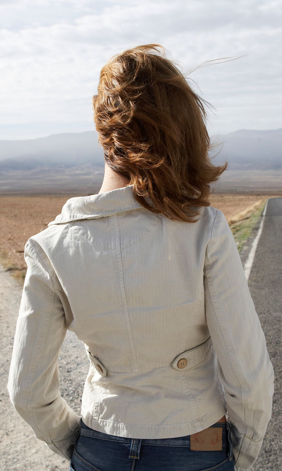 mujer mirando al horizonte, decidiendo entre dos caminos