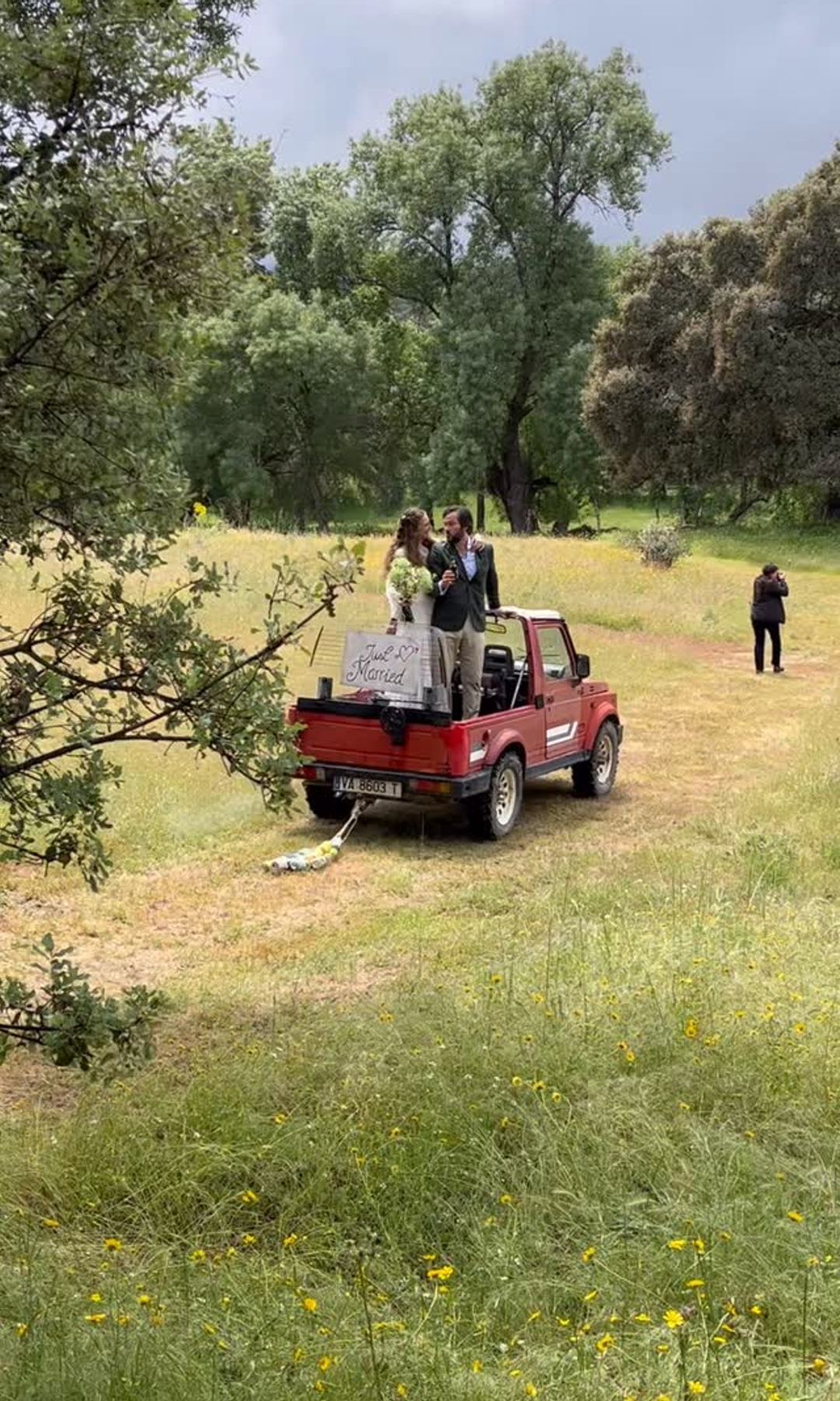 Los novios montados en su original coche nupcial