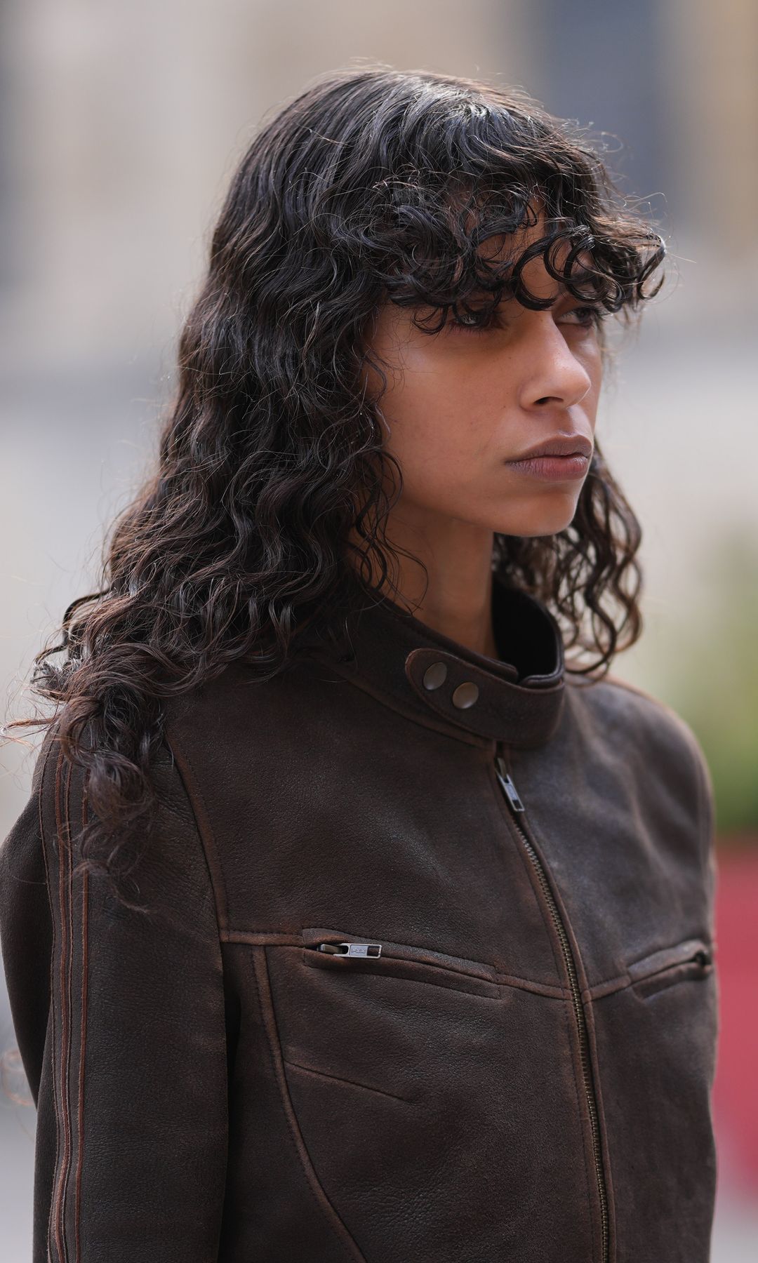 Mujer con cabello largo y rizado y flequillo rizado 