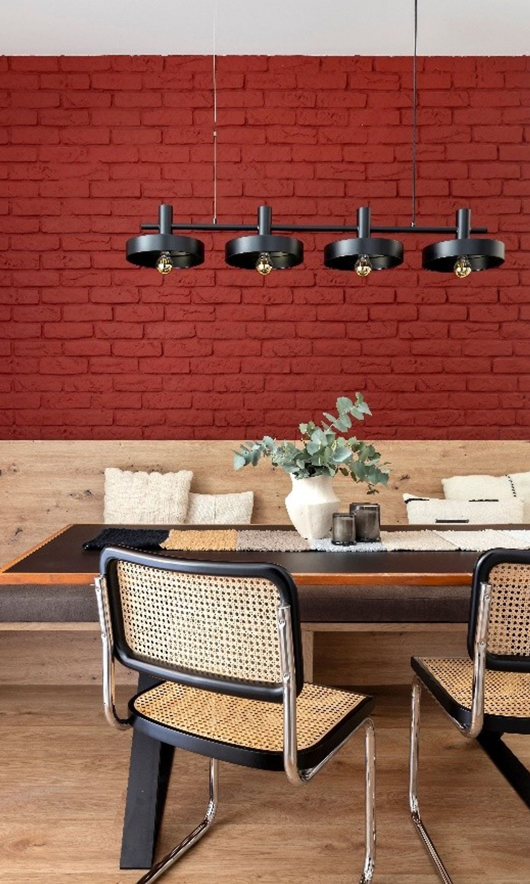 Comedor con banco, pared de ladrillo roja, lámpara de techo negra en línea, sillas Cesca, suelo de madera 
