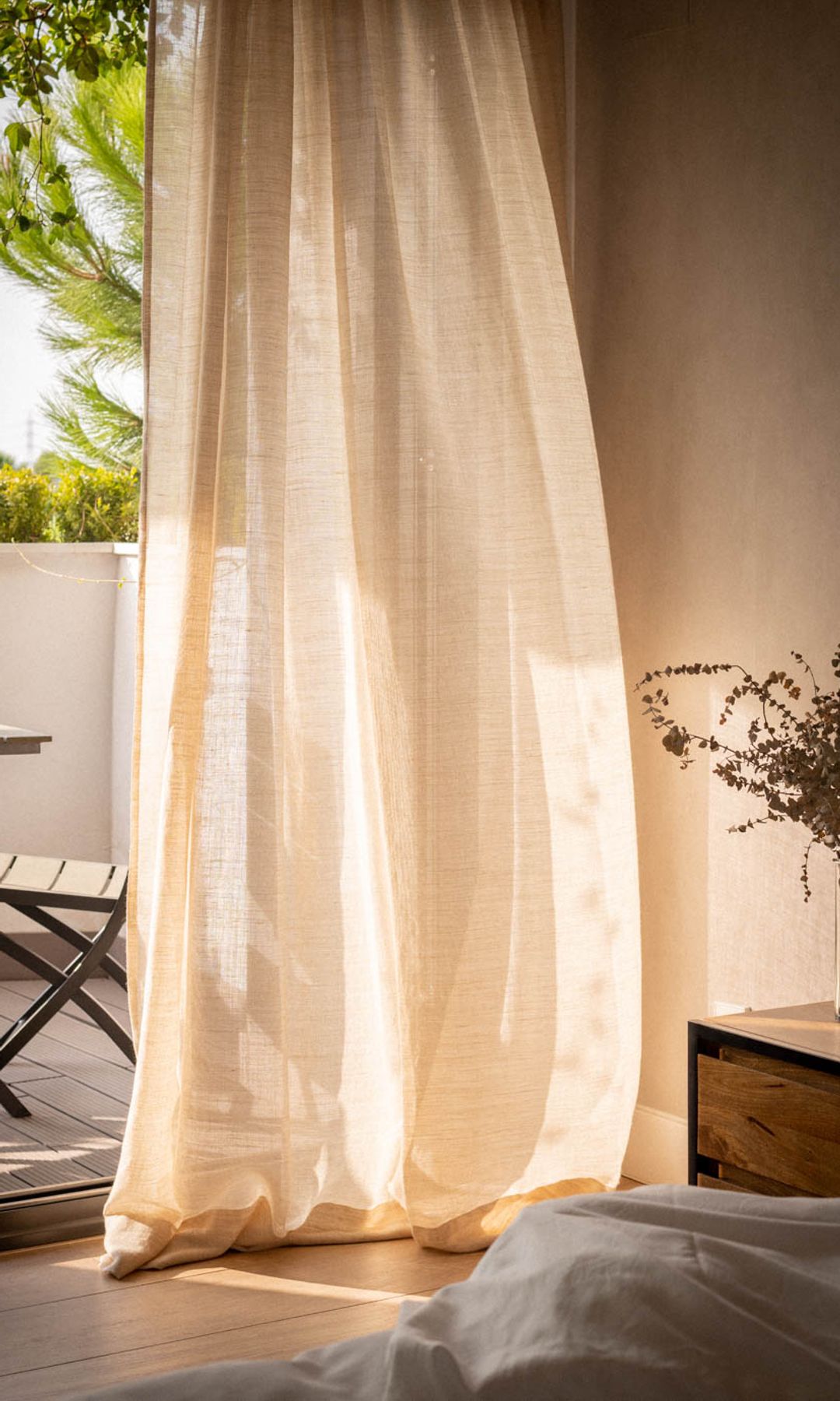 Dormitorio con cortinas de lino hasta el suelo y salida a la terraza