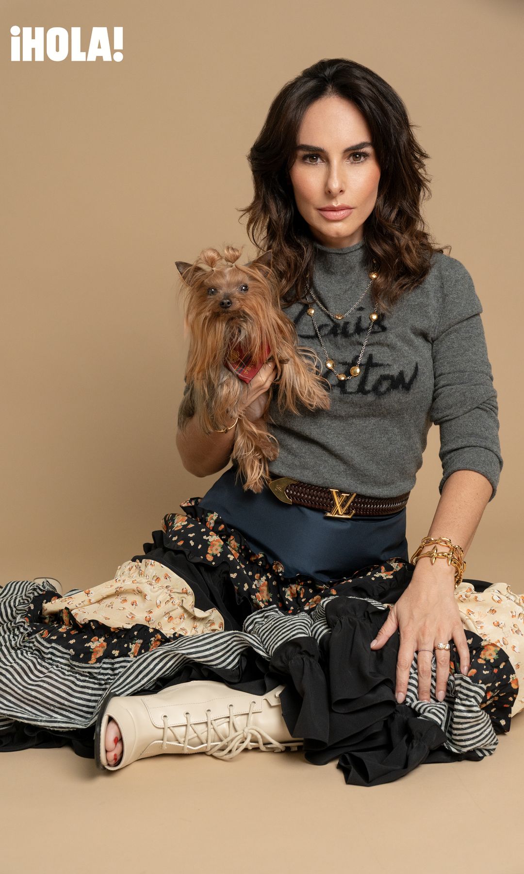 Ana deslumbra con joyería delicada, suéter gris y una falda mix & match de estampados que encarna la esencia boho-chic. Todo de Louis Vuitton. Olga la acompaña con un pañuelo estampado, también de la maison .