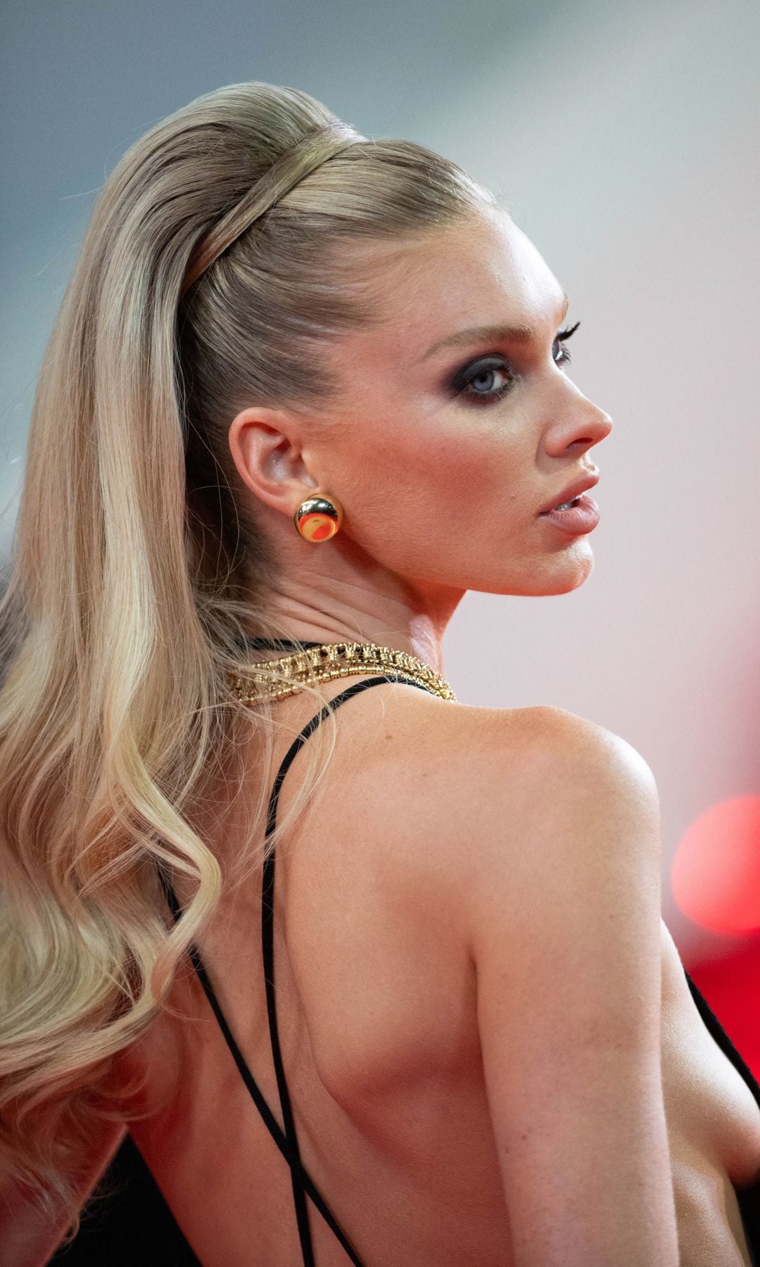 Elsa con coleta alta pulida y ondas en puntas, mirada intensa