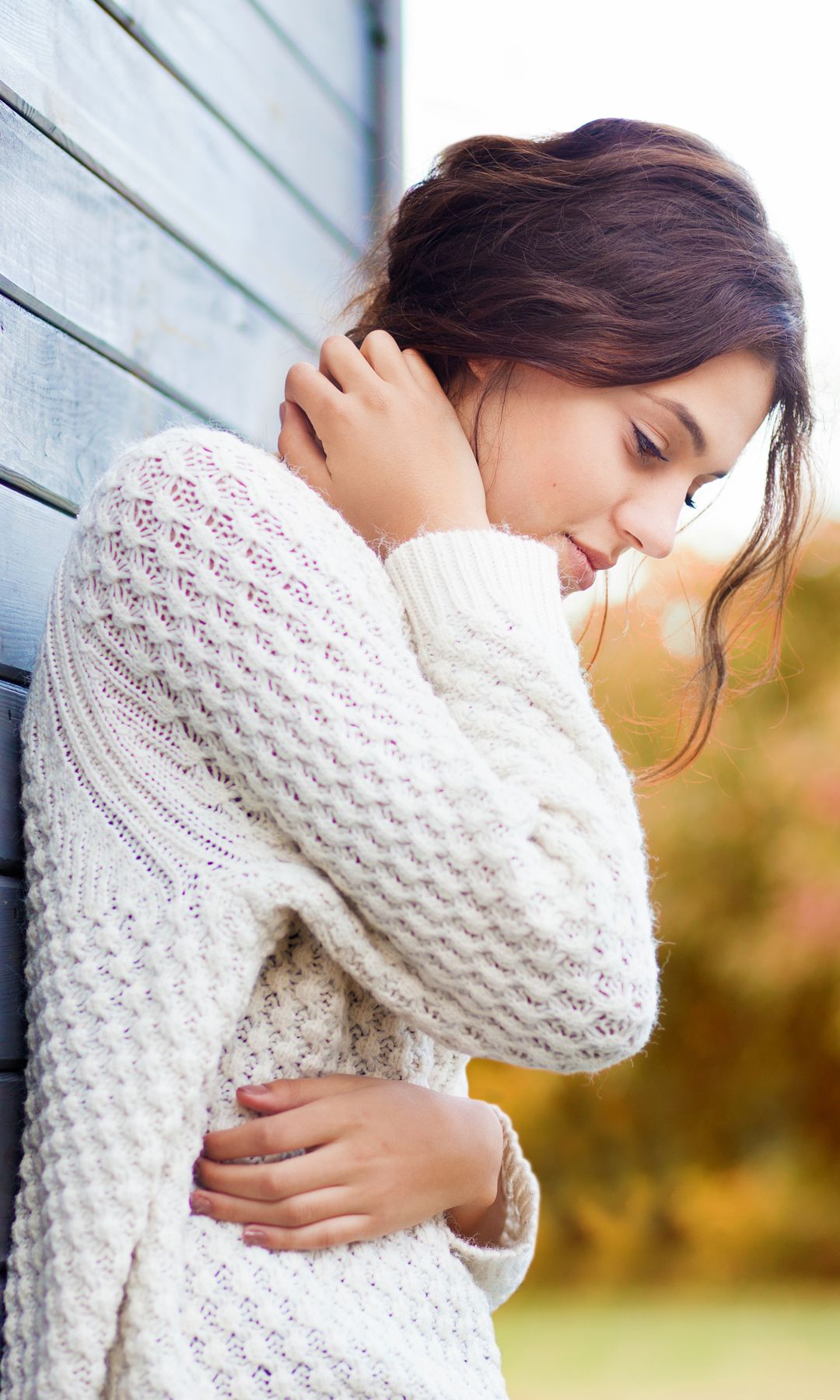 mujer pensativa apoyada en la pared