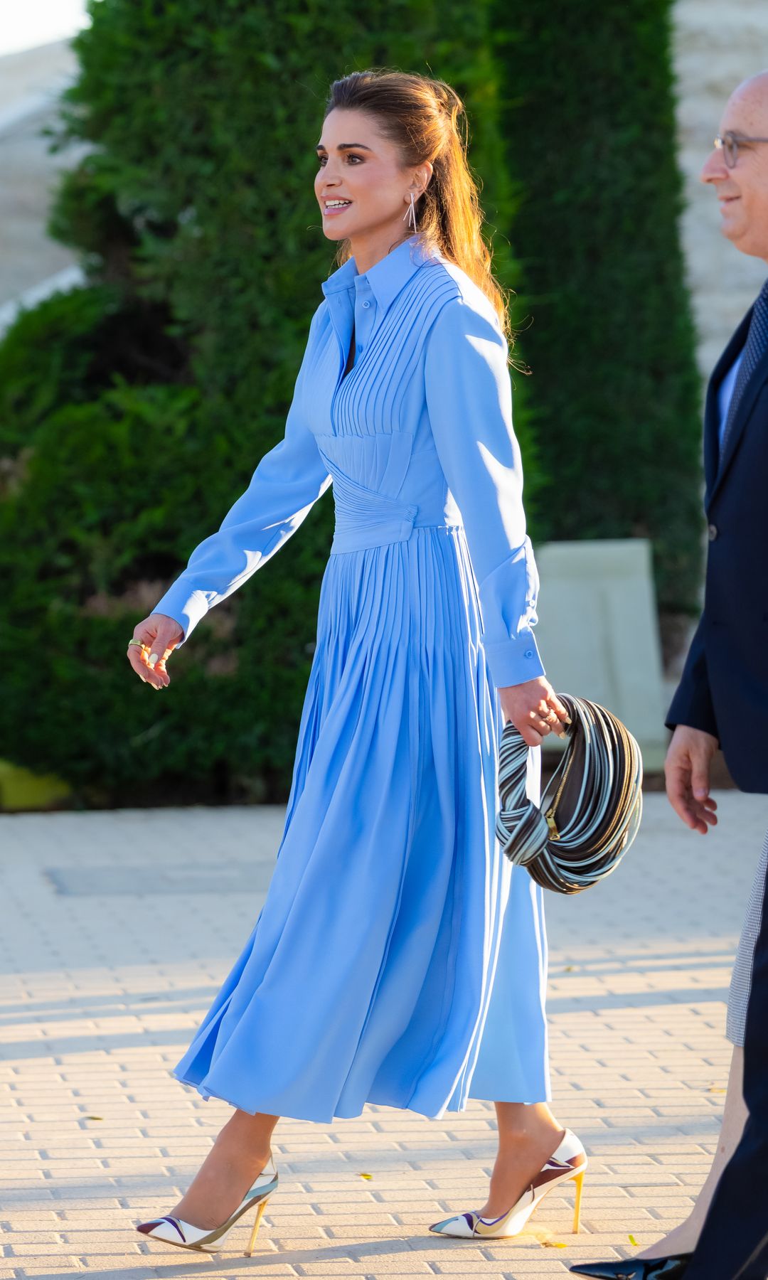 Rania de Jordania confirma que el azul es su color favorito con un elegante vestido plisado y unos exclusivos zapatos 'vintage' de hace 16 años