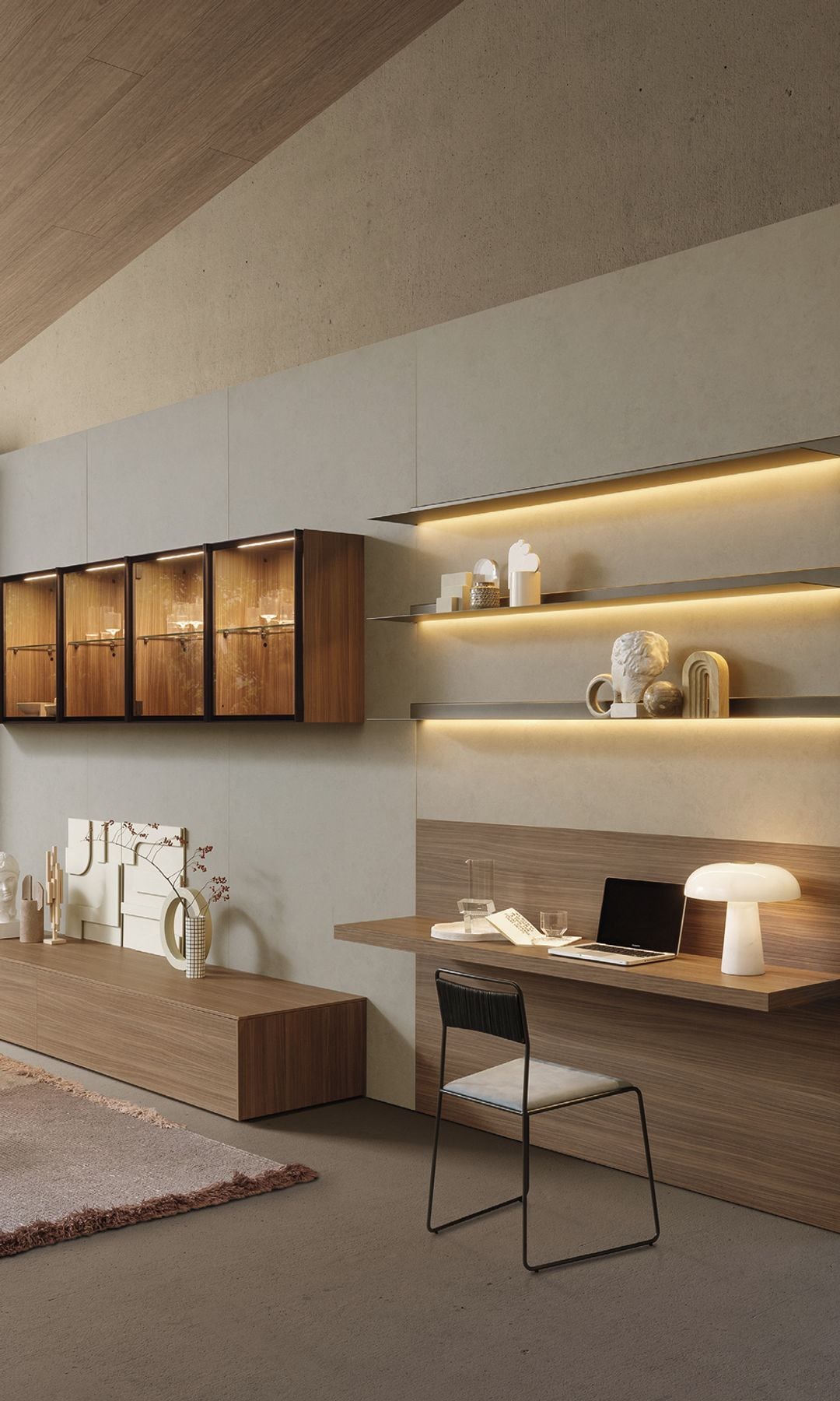 Zona de despacho en salón, con mesa de madera, lámpara de sobremesa tipo seta, silla, estanterías con luz led, vitrinas con luz interior, mueble bajo de madera