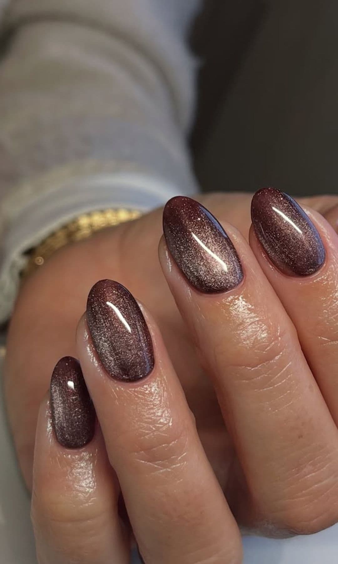 Manicura efecto velvet en tono chocolate con acabado cat eye y brillo satinado sobre uñas almendradas