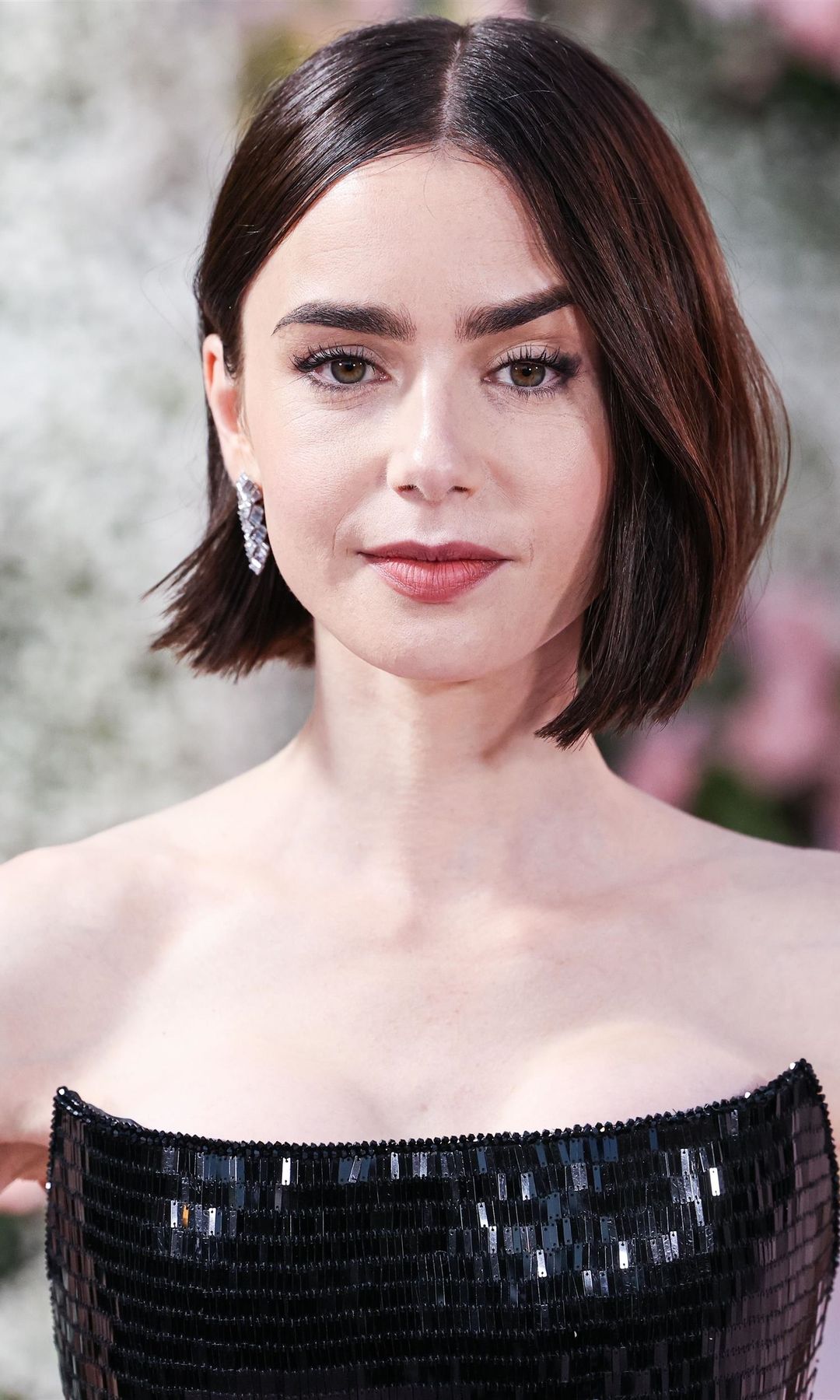 Primer plano de Lily Collins con top encorsetado negro de brillos