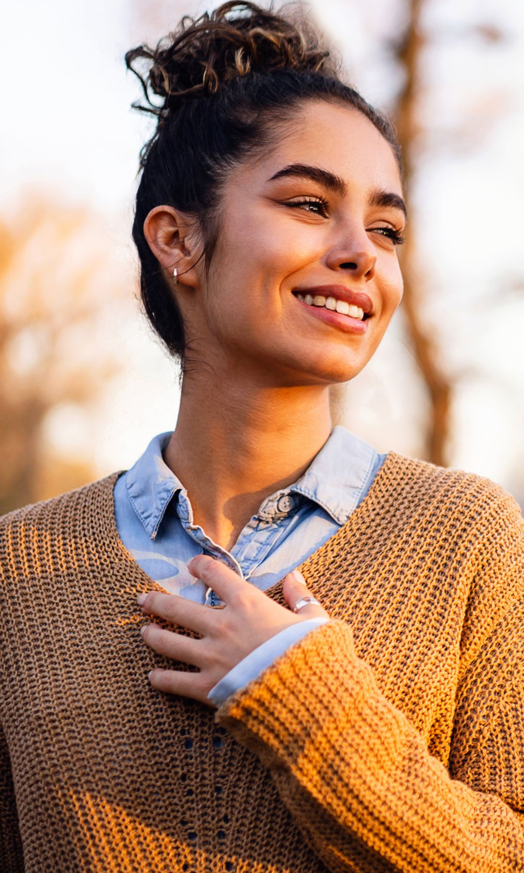 mujer pensativa y sonriente al aire libre