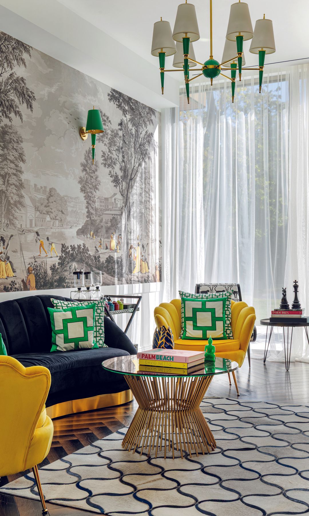 Sala de estar elegante con sofá azul, sillas amarillas, mesa de vidrio y mural paisajístico.