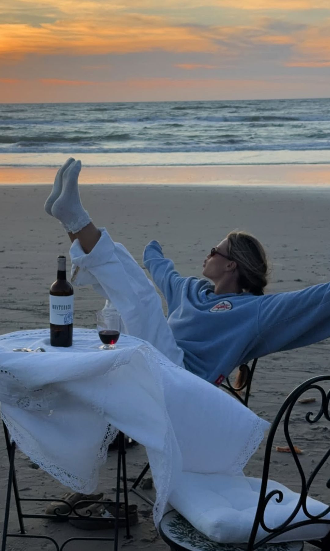 La influencer hannaschonberg celebrando en la playa con una botella de vino