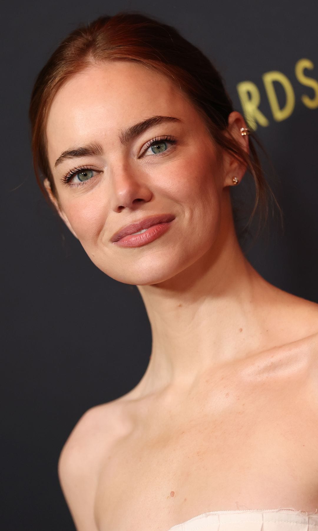 Emma Stone, camino a los Oscar, deslumbra en los AFI Awards con un vestido blanco y un 'ear cuff' de diamantes