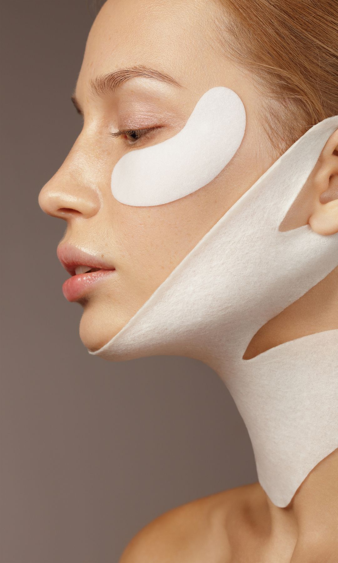 Una mujer con una mascarilla de cuello y unos parches para ojeras