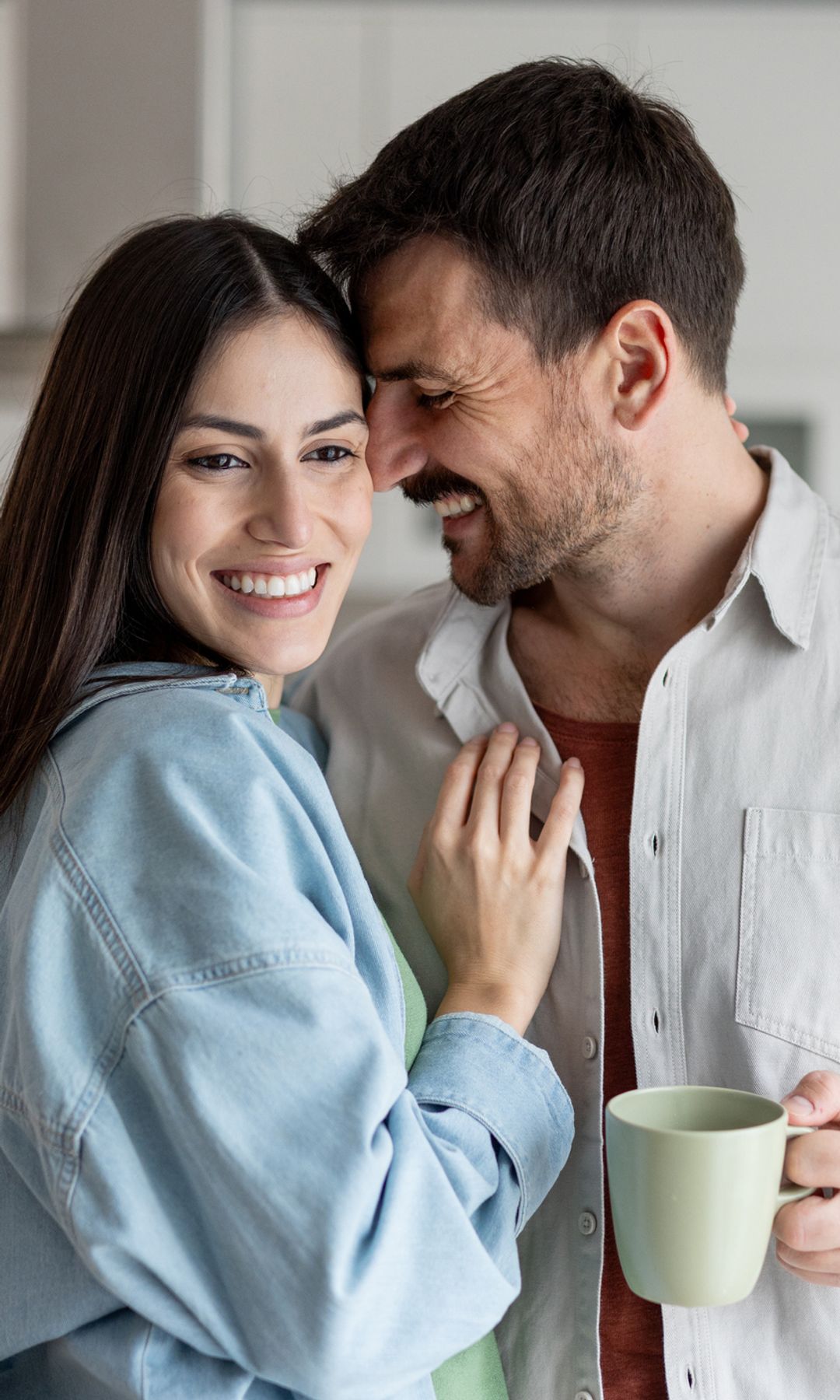 Pareja joven feliz en la cocina en el desayuno