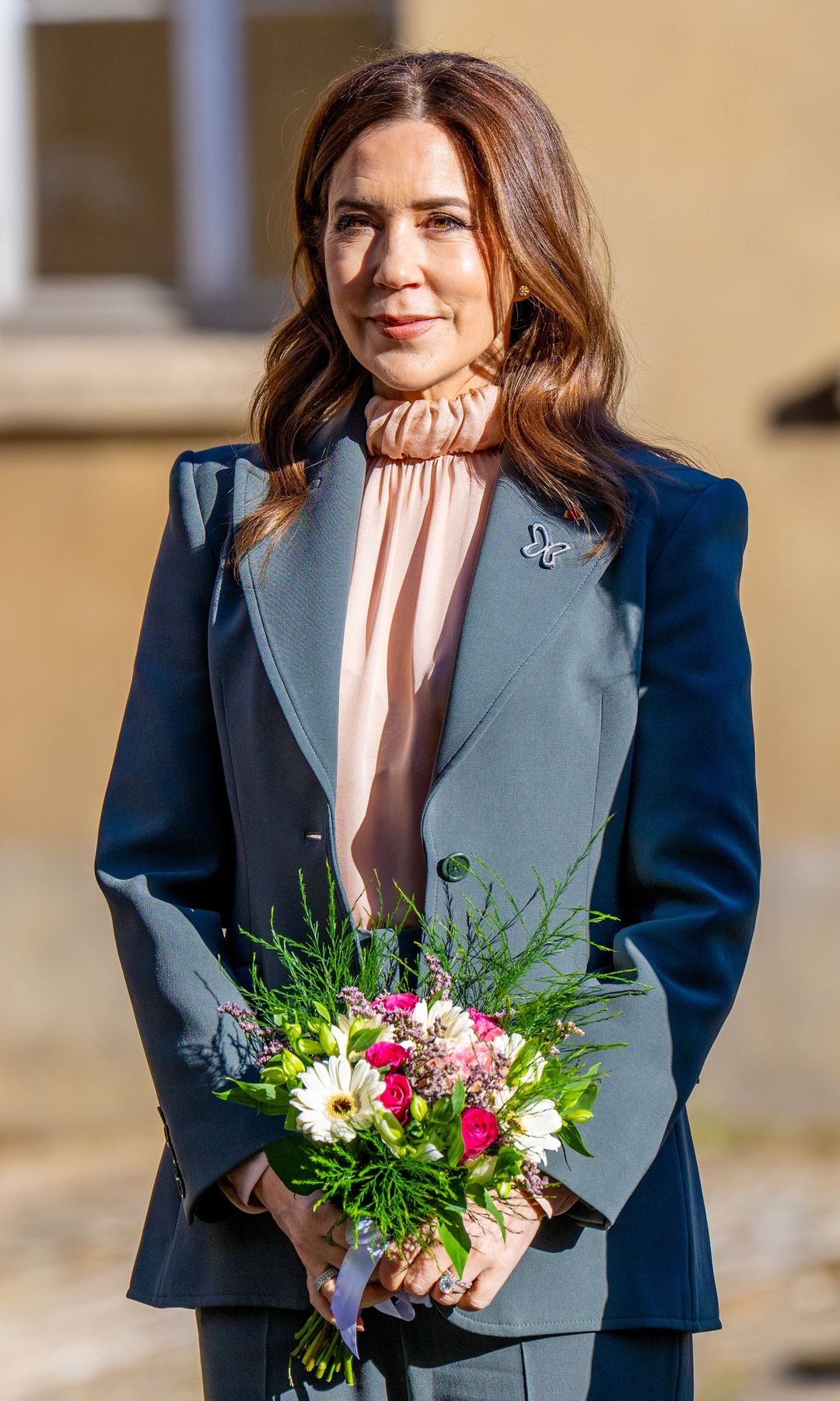Mary de Dinamarca ya viste como las parisinas: romántica blusa drapeada y traje con hombreras