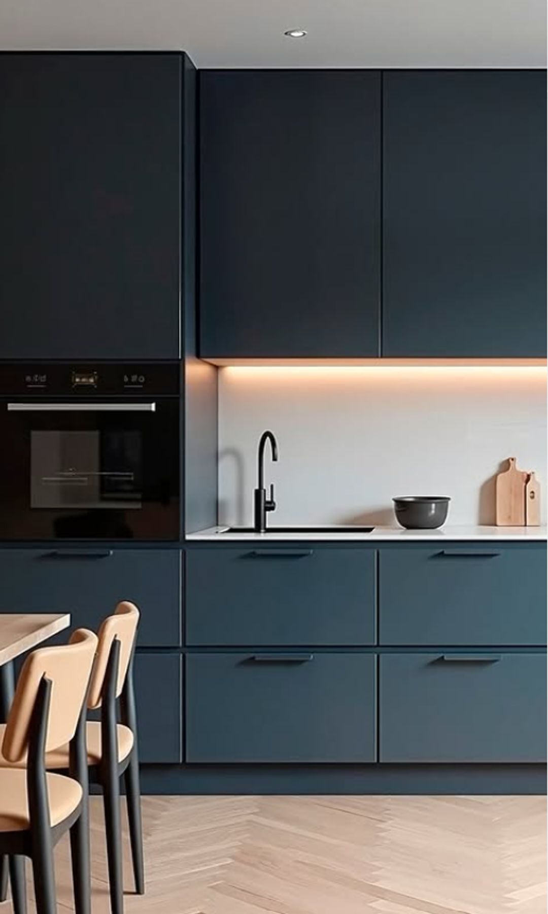 Cocina con comedor con muebles en gris oscuro, led bajo los armarios altos, horno en columna