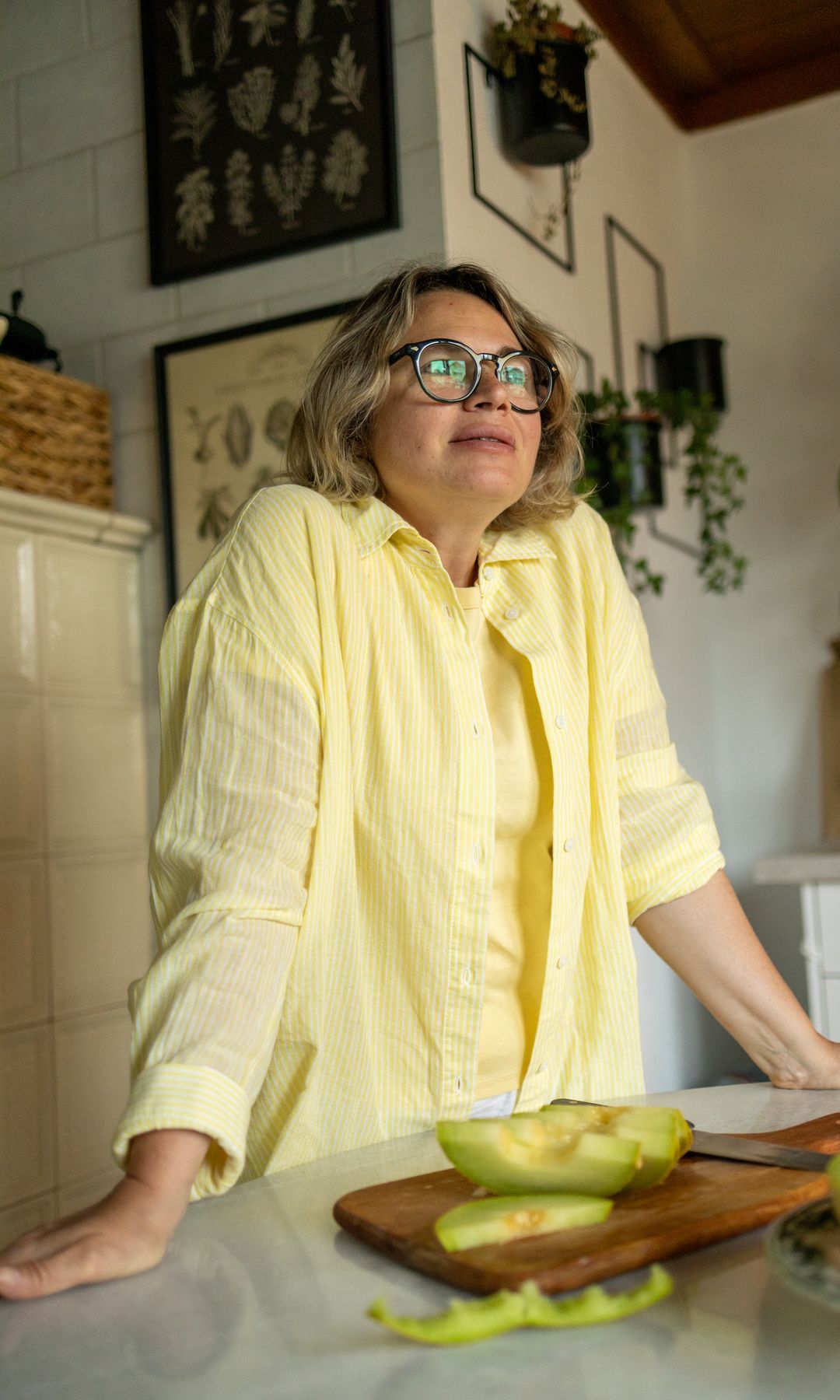 Mujer vestida de amarillo preparando un melón