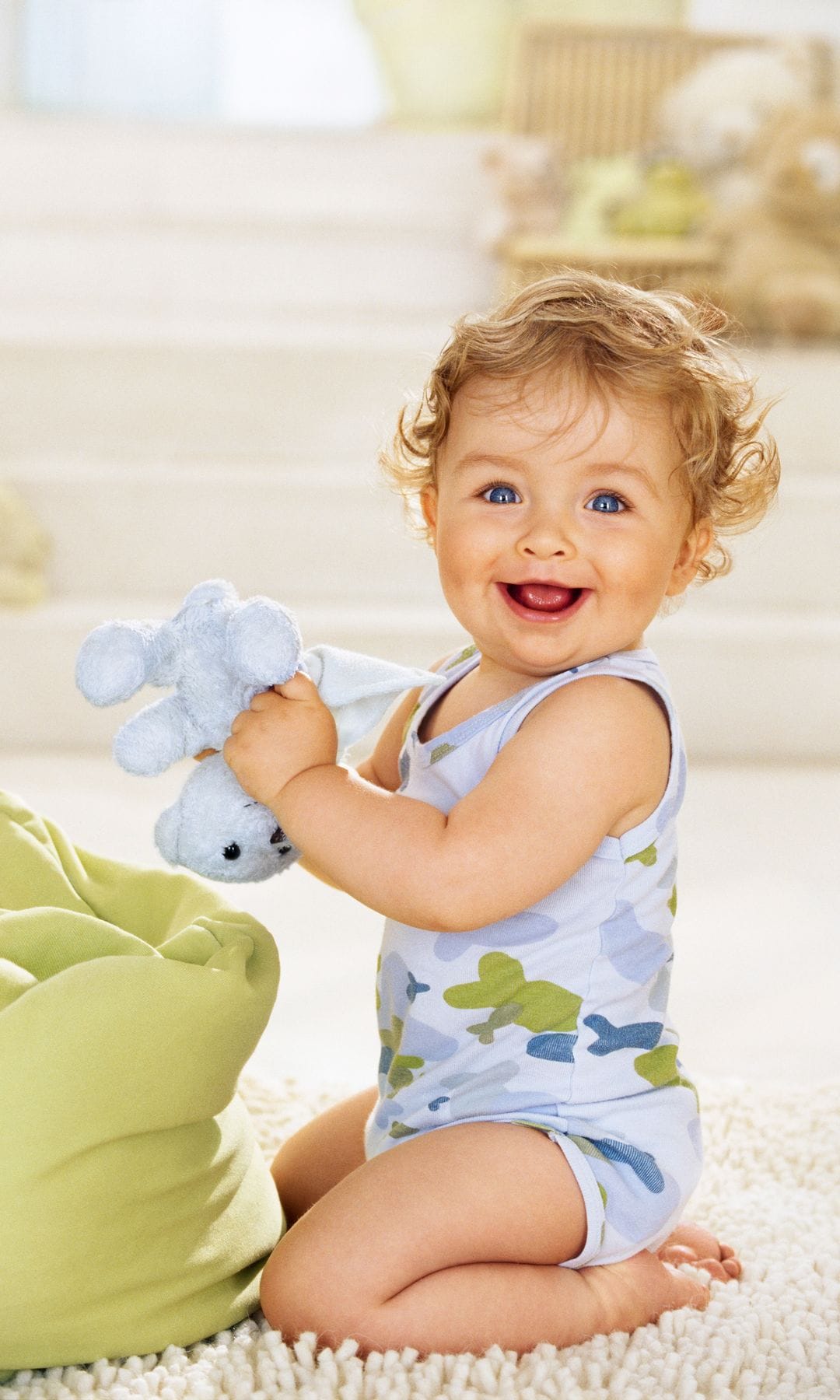 Niño pequeño sonríe mientras coge su peluche