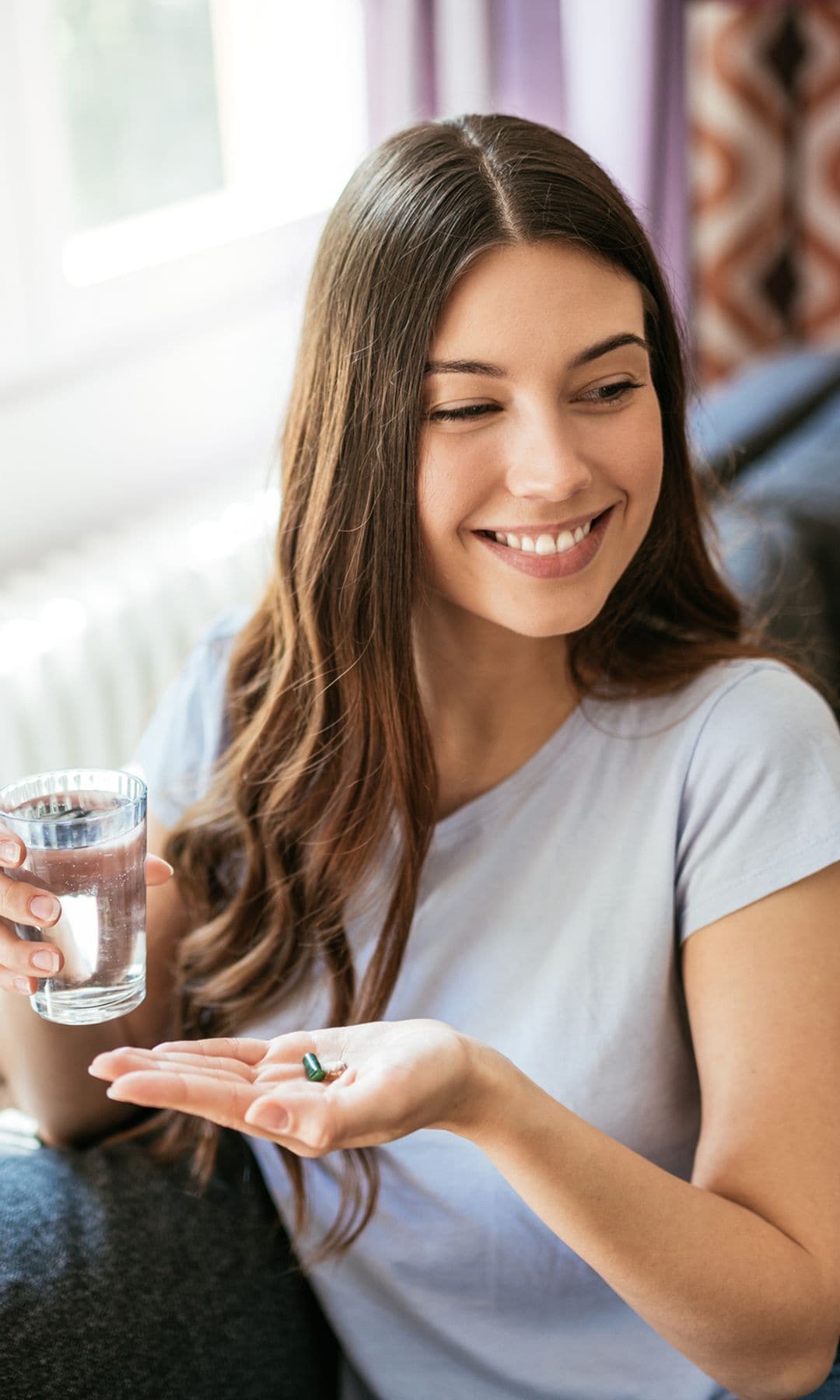 Una mujer joven tomando sus suplementos nutricionales