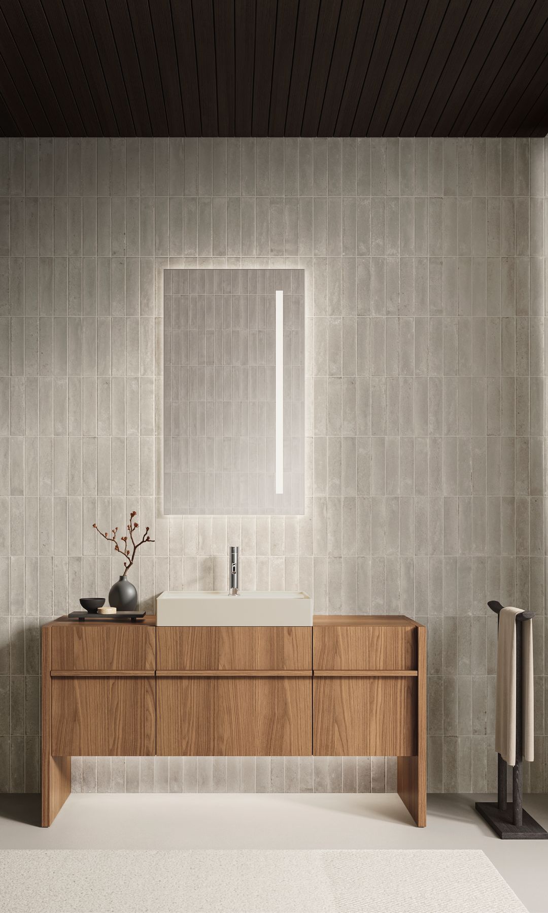 Baño con mueble de lavabo de madera, espejo retroiluminado vertical y toallero de pie