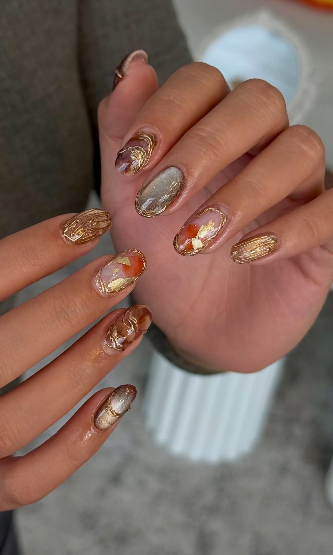 Manicura multicolor con detalles en dorado 