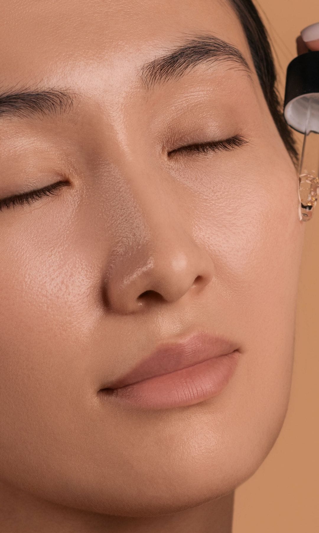 Una mujer asiática aplicándose un sérum