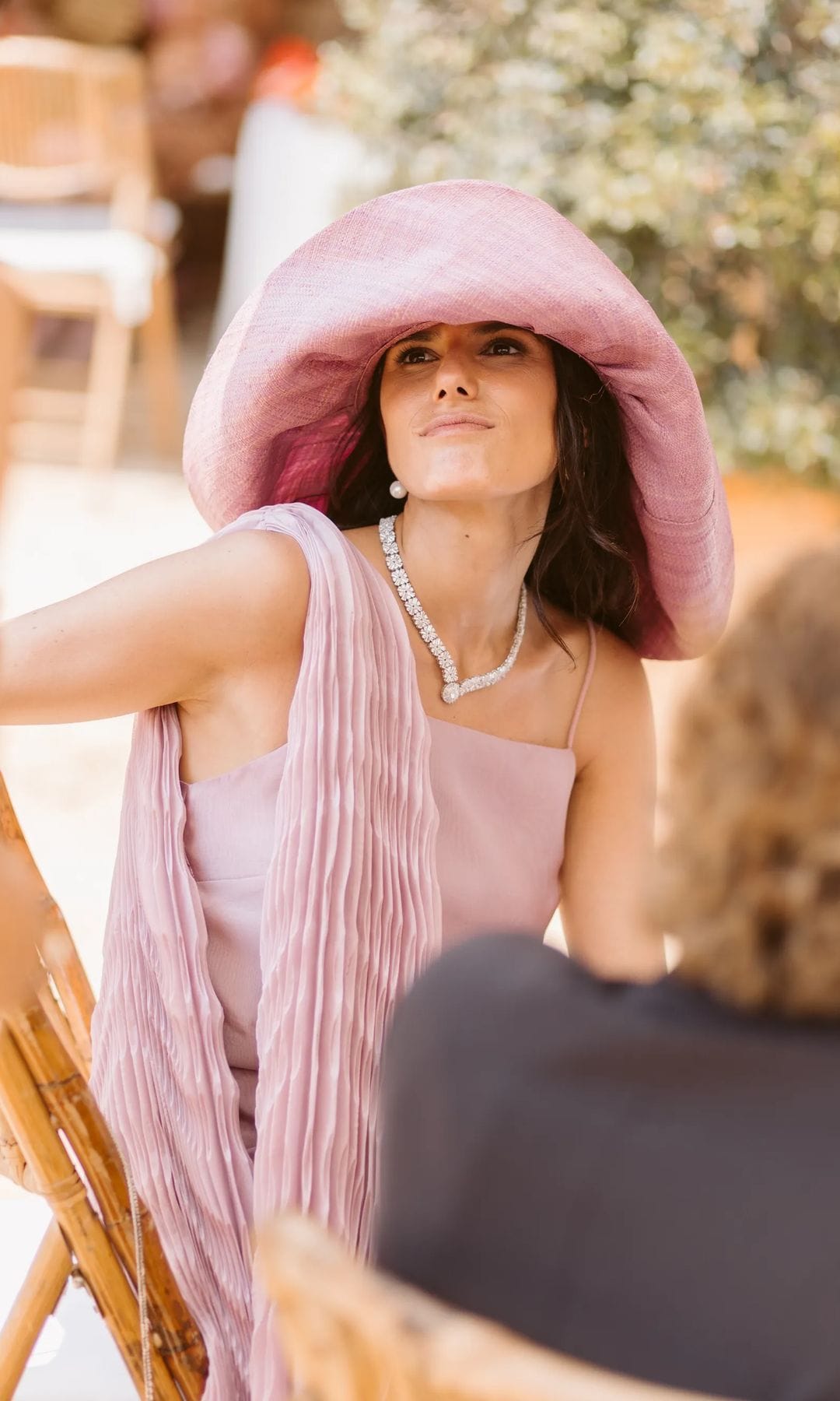Ser la hermana de una novia sevillana y triunfar sin eclipsarla: un vestido de invitada rosa, pamela y diamantes familiares