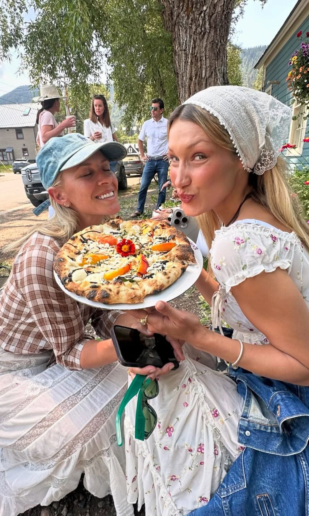 Bella Hadid posa junto a una mujer mientras comparten una pizza al aire libre