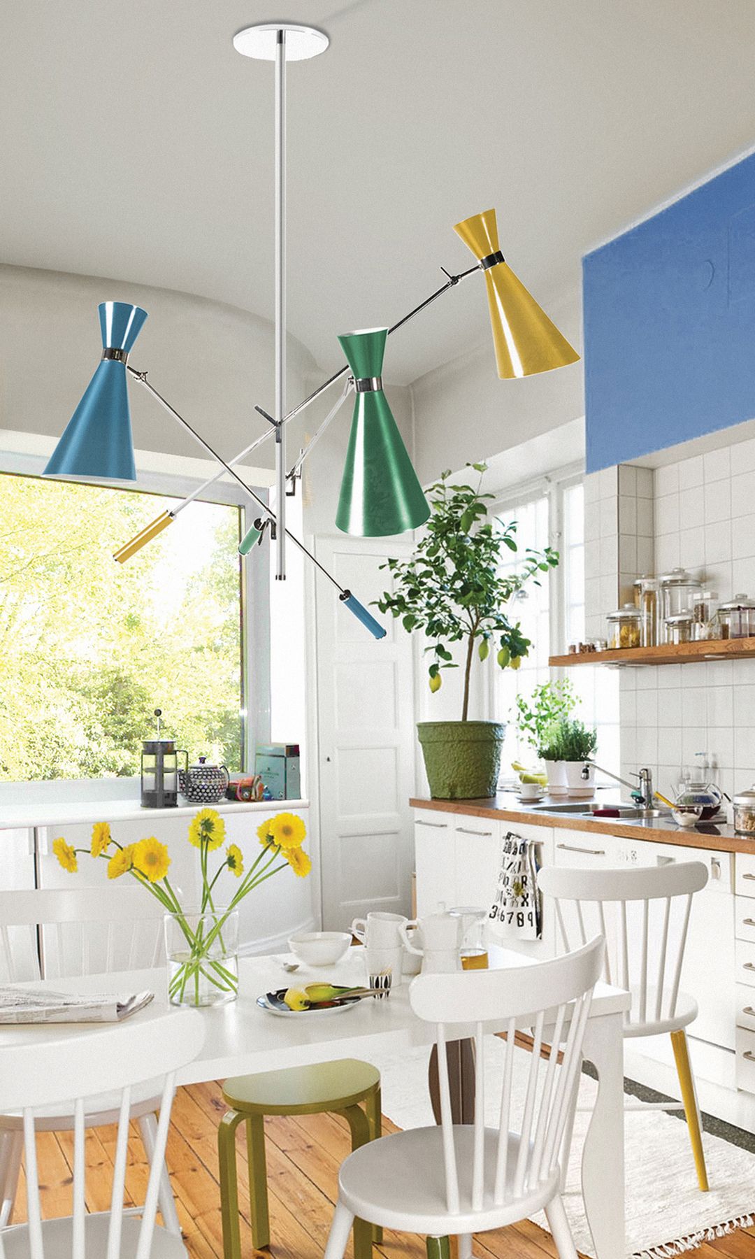 Cocina blanca con offices con mesa y sillas blancas, paredes de azulejos blancos, mueble superior azul, lámpara de techo con pantallas de colores