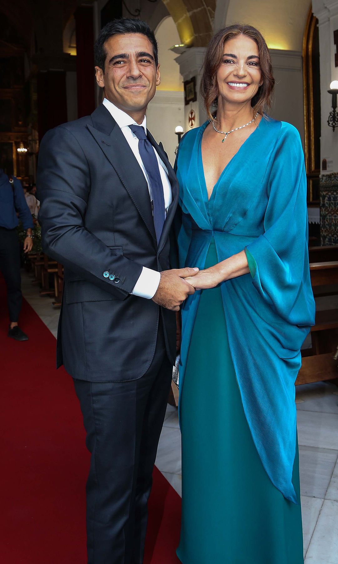 Alberto Herrera, con traje firmado por Tomás Laso-Argos, junto a su madre y madrina, Mariló Montero, que llevaba vestido diseñado en exclusiva por Sybilla, zapatos de Manolo Blahnik y collar de diamantes y esmeraldas, anillo y pendientes de Suarez