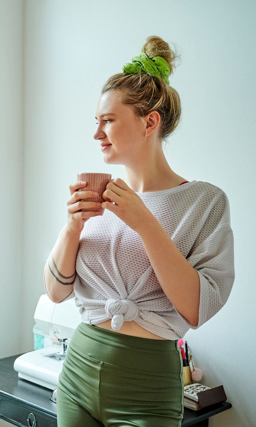 Una mujer tomandose un café antes de hacer ejercicio
