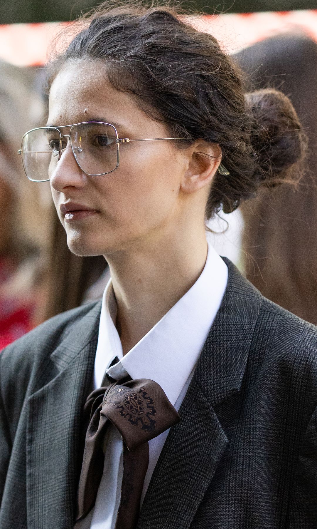Invitada a la Semana de la Moda de Milán con moño rizado y gafas