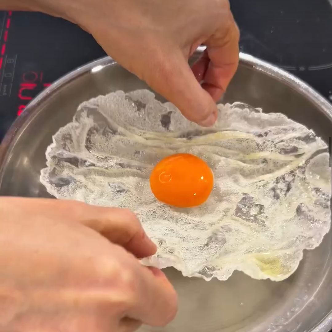 Papel de arroz frito en la sartén con yema de huevo