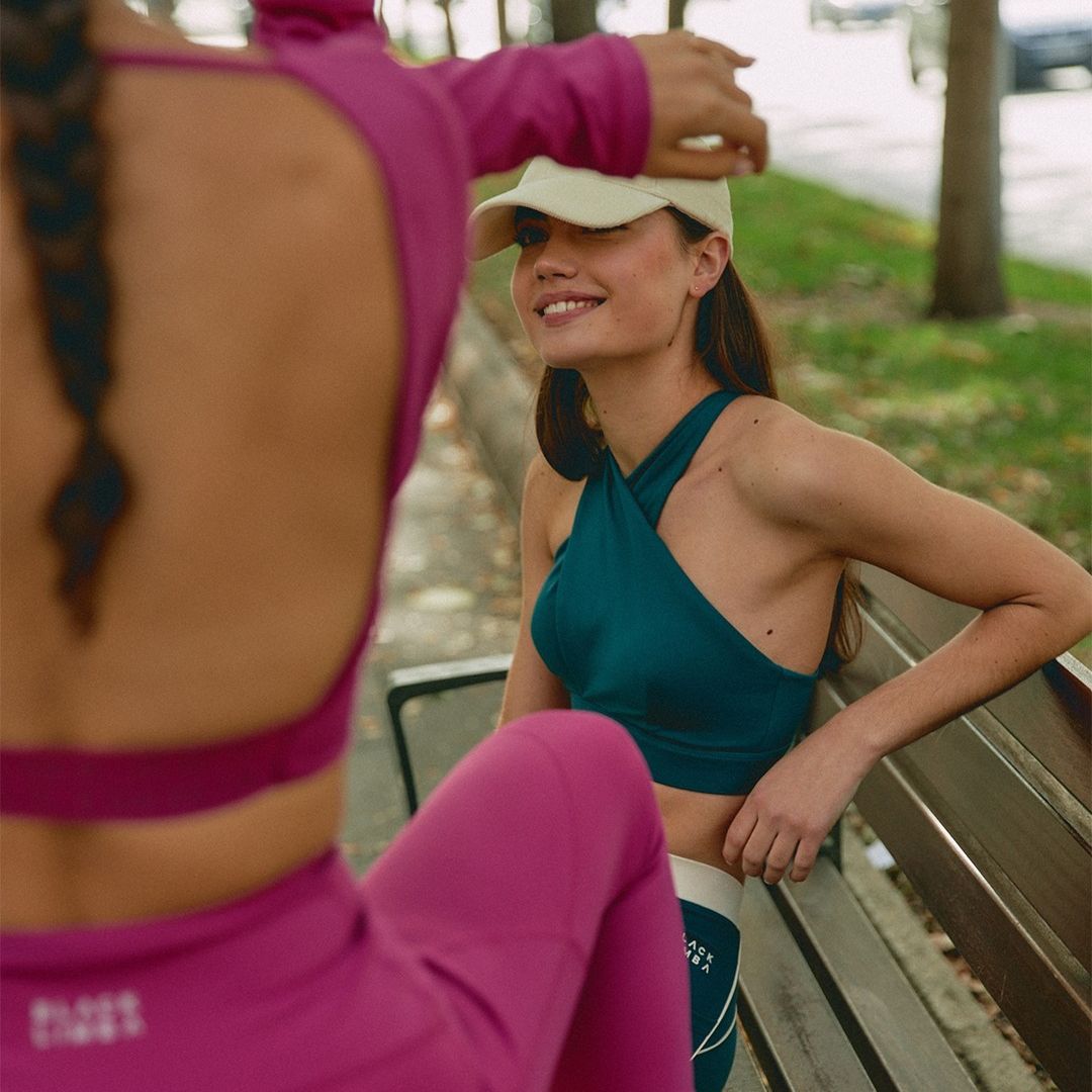 Dos amigas haciendo ejercicio conjunto verde y rosa