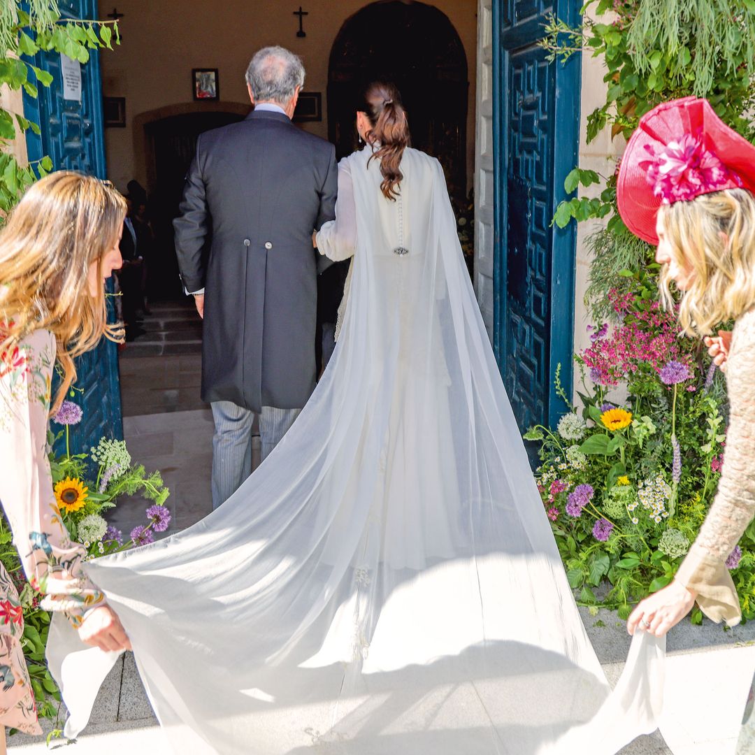La novia a su llegada a la iglesia de Santo Tomás de Canterbury, del brazo de su padre, en una foto que resalta la preciosa espalda del vestido