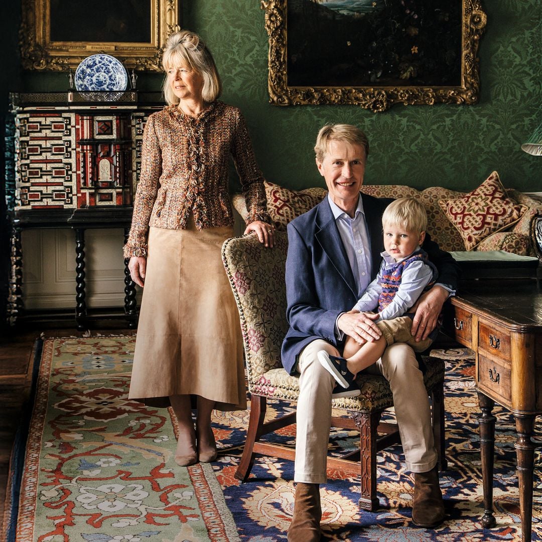 Hombre y mujer con un niño en una sala decorada. El hombre sostiene al niño en su regazo.