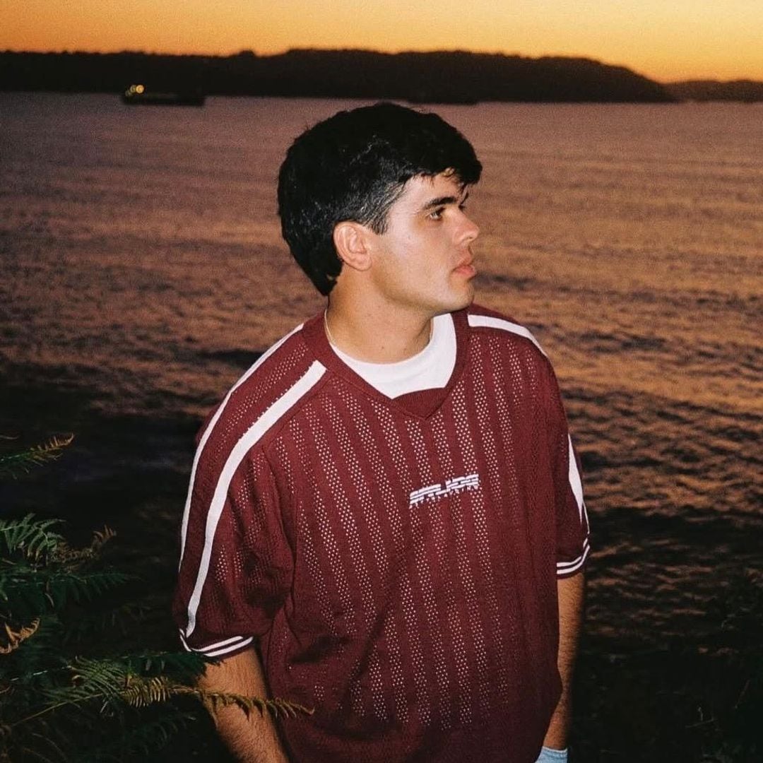 Iñigo Quintero en un atardecer con camisa roja con detalles blancos 
