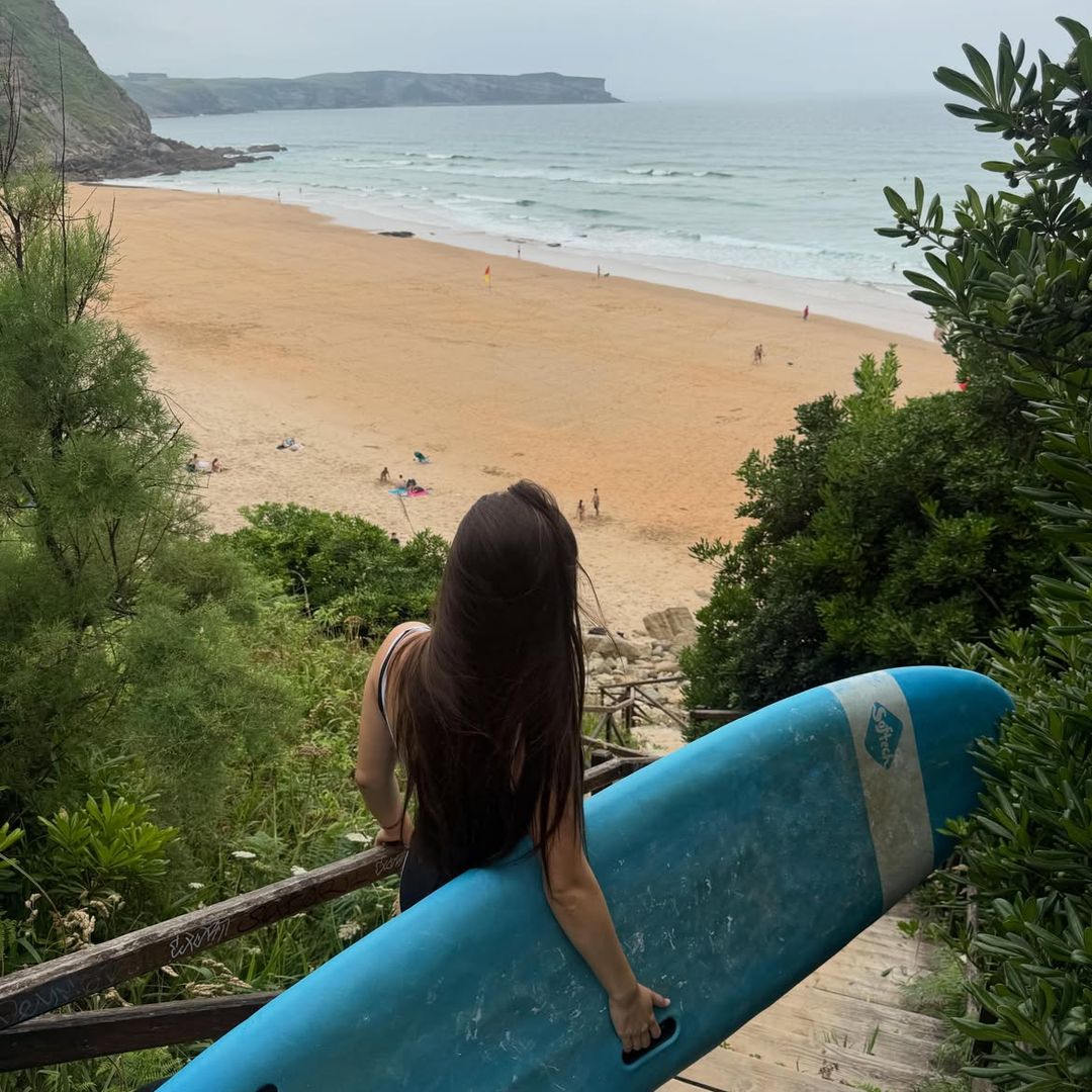 Daniela Cambrones Meroño con su tabla en la playa de Los Locos de Suances, Cantabria