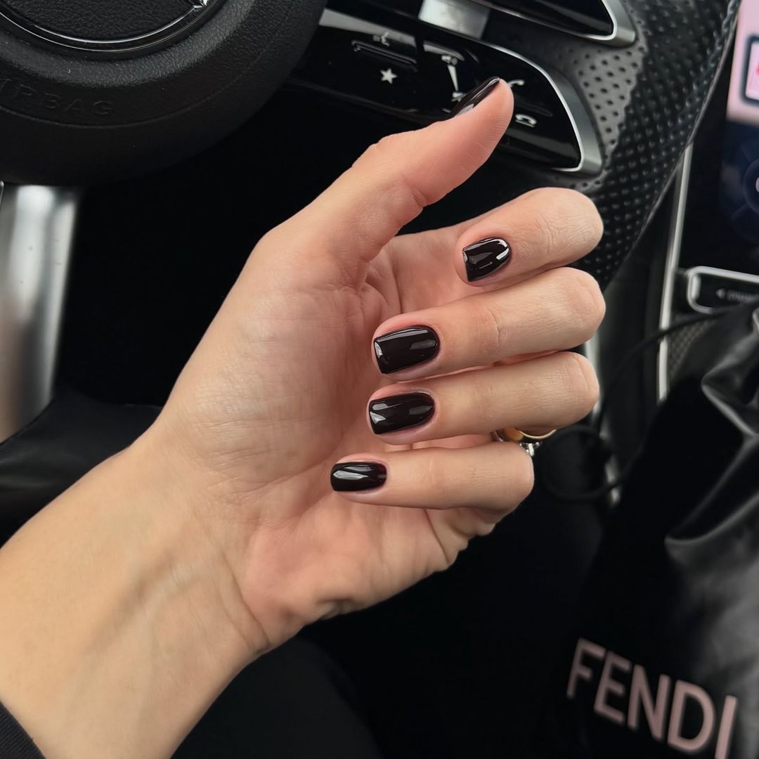 Manicura negra con bolso Fendi de fondo