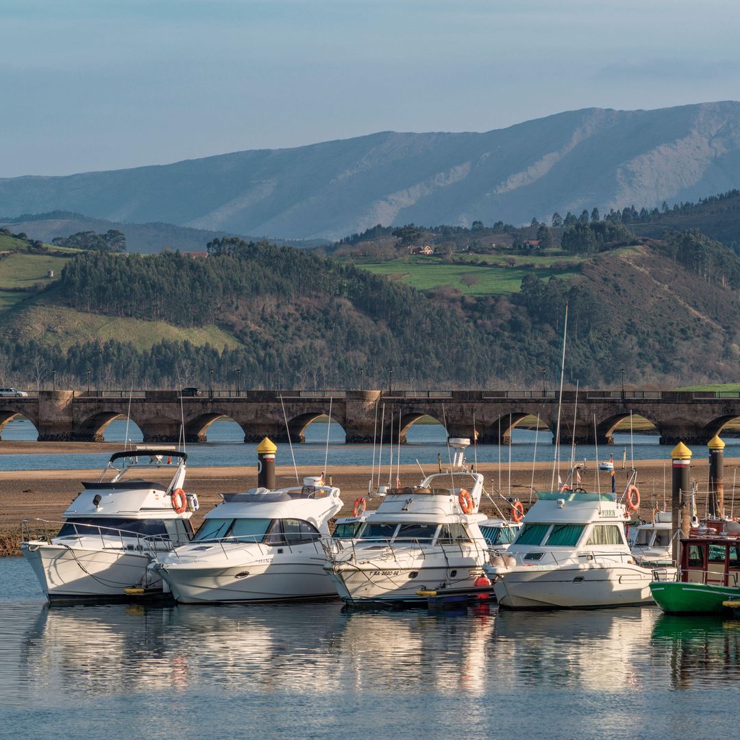 Barcos recreativos en la ría y al fondo el puente de la Maza, San Vicente de la Barquera, Cantabria