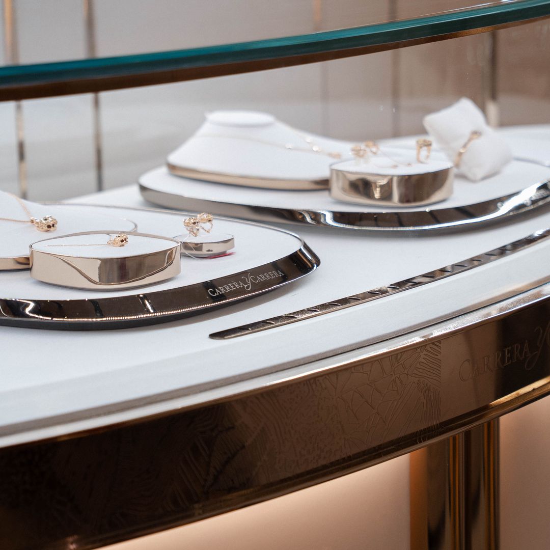 Exhibición de joyas de lujo en una vitrina con diseños de oro y plata.