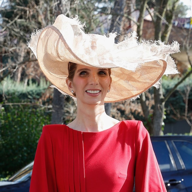 Plano medio de Margarita Vargas con vestido rojo y sombrero beige