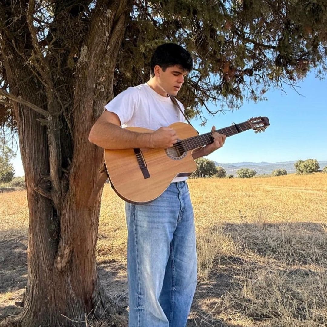 Iñigo Quintero tocando la guitarra bajo en árbol
