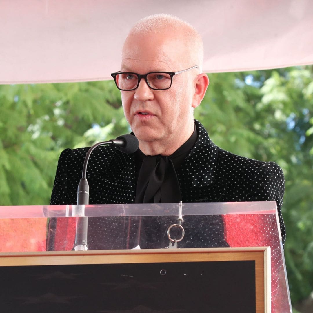 Ryan Murphy, con gafas y traje negro punteado, habla en el podio del Hollywood Walk of Fame.
