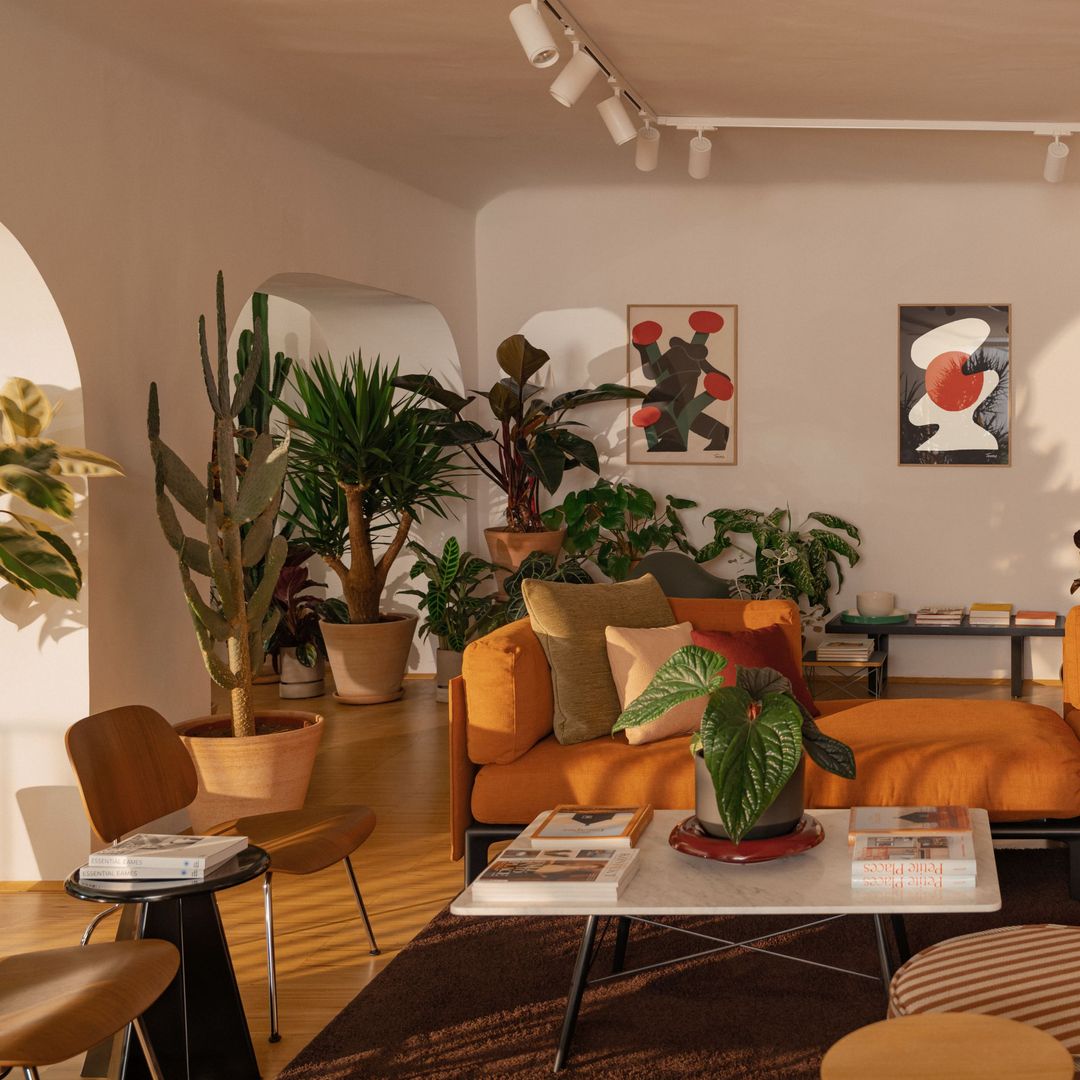 Salón con sofá naranja y sillas de vitra